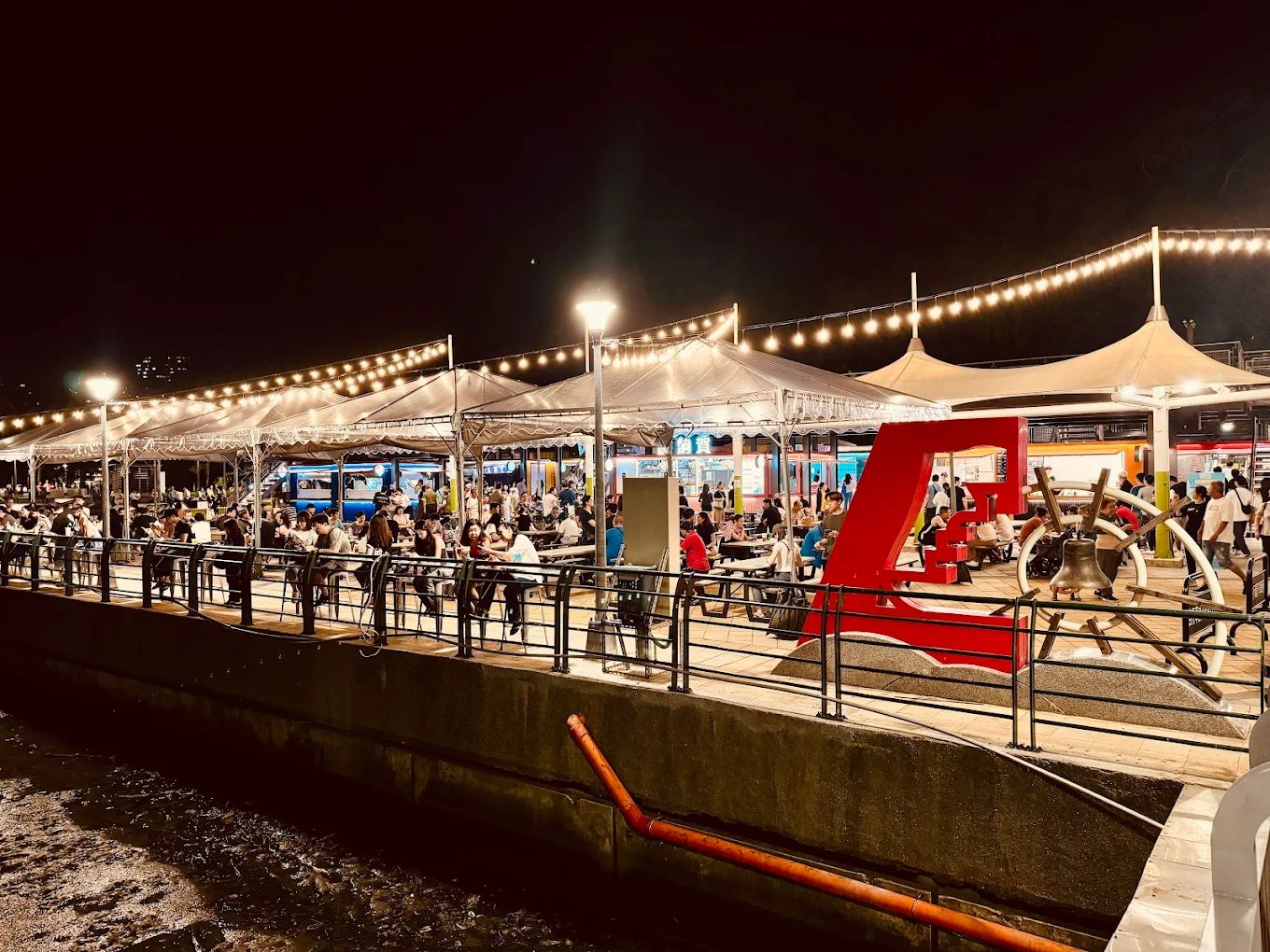 關渡碼頭貨櫃市集全景，夕陽灑落在繽紛的貨櫃與人潮上