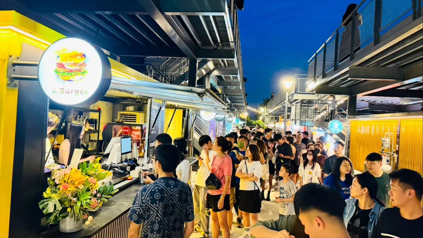 碼頭市集夜晚熱鬧景象，燈光點亮了貨櫃屋