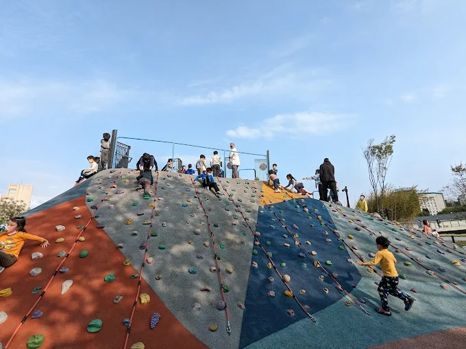 小朋友挑戰復興親子公園的彩色攀岩牆坡道，結合繩索與岩塊設計，是熱門的親子冒險遊戲設施
