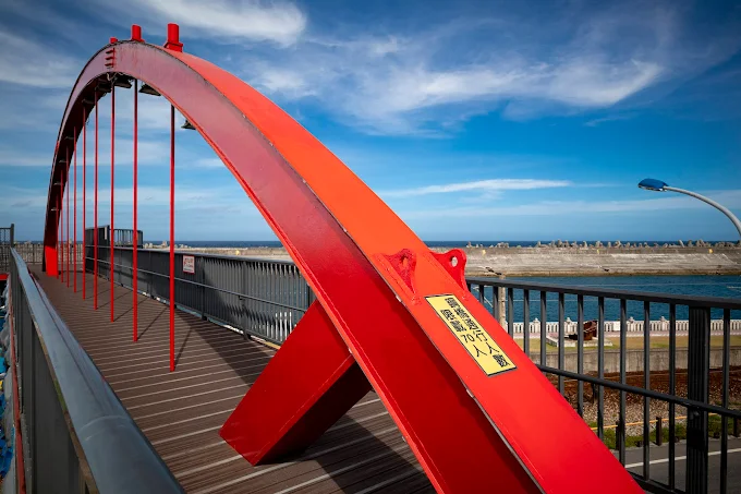 紅色拱形的花蓮港景觀橋橫跨海岸線上，成為自行車道的地標