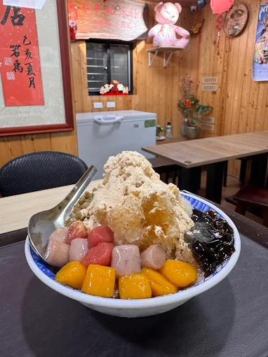 刨冰上覆蓋各式芋圓、粉粿與仙草，擺放在木桌上
