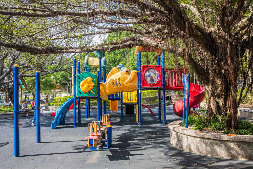 桃園奧爾森林學堂的兒童遊戲場設於大樹下，擁有彩色滑梯與攀爬設施，提供清涼安全的玩樂環境
