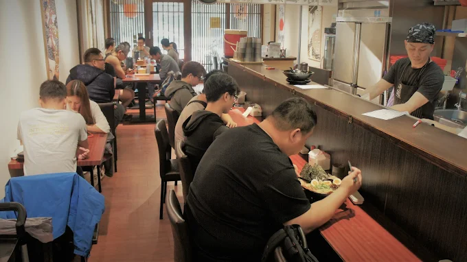 「台中佐原拉麵店內用餐環境，開放式吧台與座位區座無虛席」
