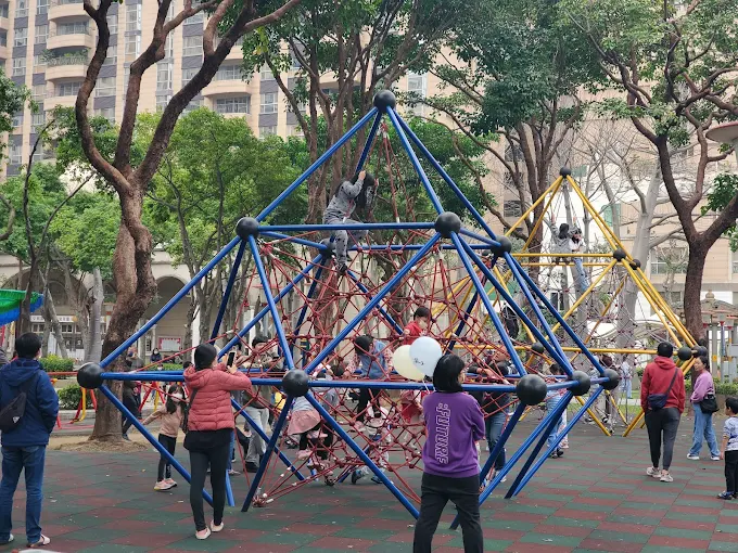 桃園同安親子公園設有大型立體繩網金字塔，小朋友正在攀爬玩耍，適合訓練體能與平衡感
