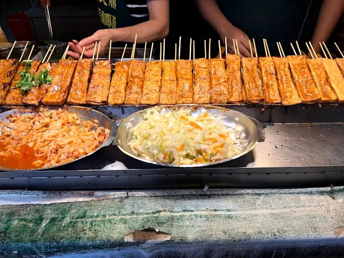 在大樹下品嚐現烤的串燒臭豆腐，是許多遊客對於深坑老街最鮮明的記憶。