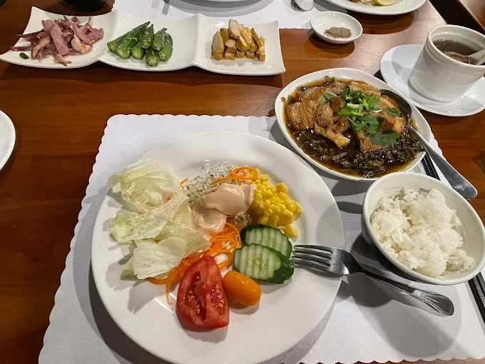 三富休閒農場餐桌餐點，包含沙拉、新鮮蔬菜、滷肉料理與白飯，展現健康在地飲食特色