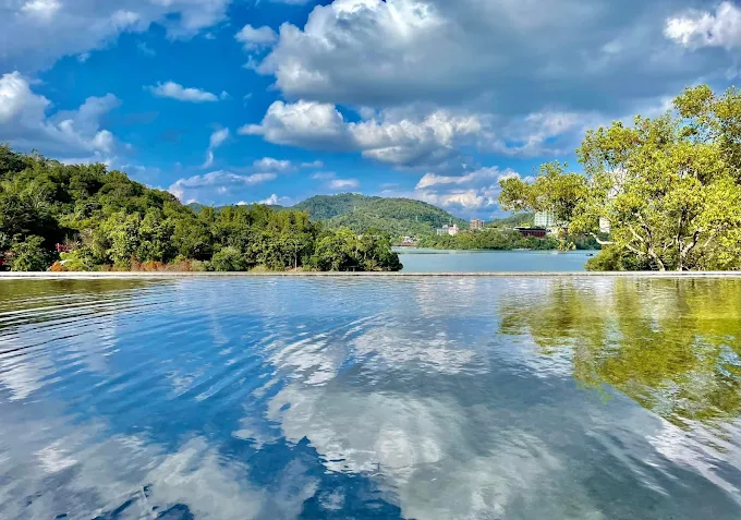 向山觀景平台湖面倒映藍天白雲與遠方山景
