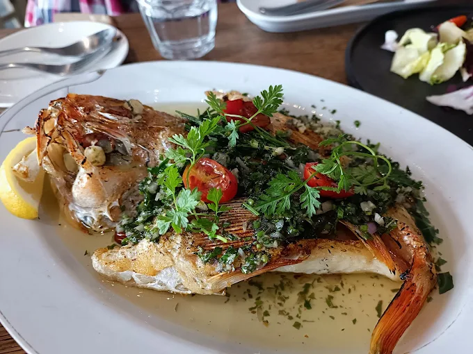 嶼我餐廳精心烹調的地中海風海鮮料理,鮮嫩的烤魚配上清爽配菜,視覺與味覺雙重享受。