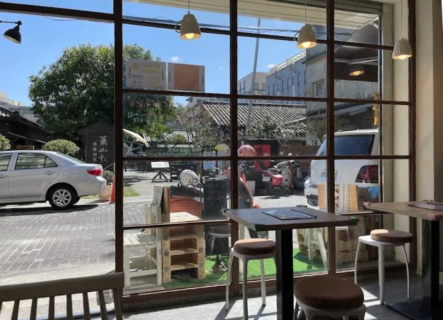 竹東文青咖哩店塊肉究派的外觀，大面落地窗映照著街景