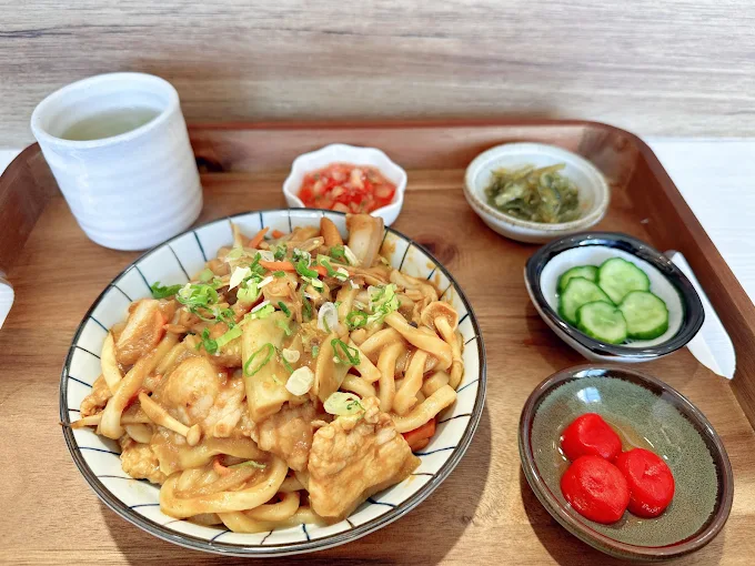 菜多多醬燒炒烏龍麵定食，上方撒滿柴魚片與溏心蛋