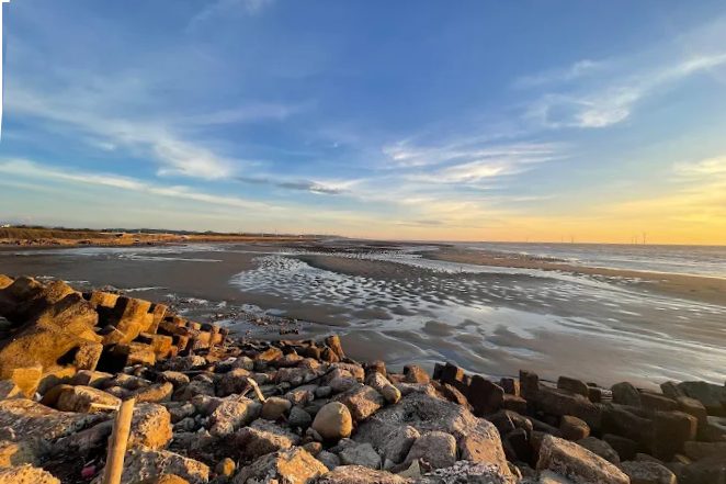 苗栗後龍外埔漁港夕陽美景,潮間帶沙灘與防波堤石塊