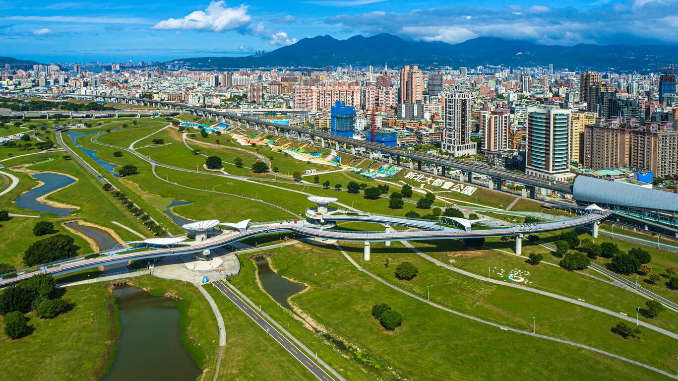 新北大都會公園全景綠意，孩子們在遼闊的草坡上盡情奔跑與玩耍