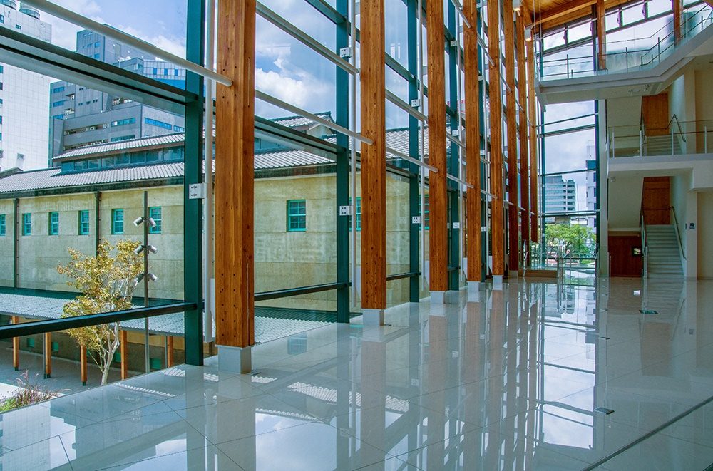 美術館內的玻璃長廊，光影穿透其間，展現出集成木構與現代建築的工藝美學。