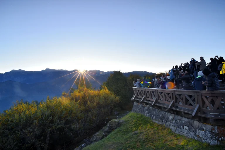 清晨的阿里山，金黃色的陽光灑落在層層疊疊的雲海之上，勾勒出遠方山巒的剪影，這是祝山觀日平台最經典的畫面。