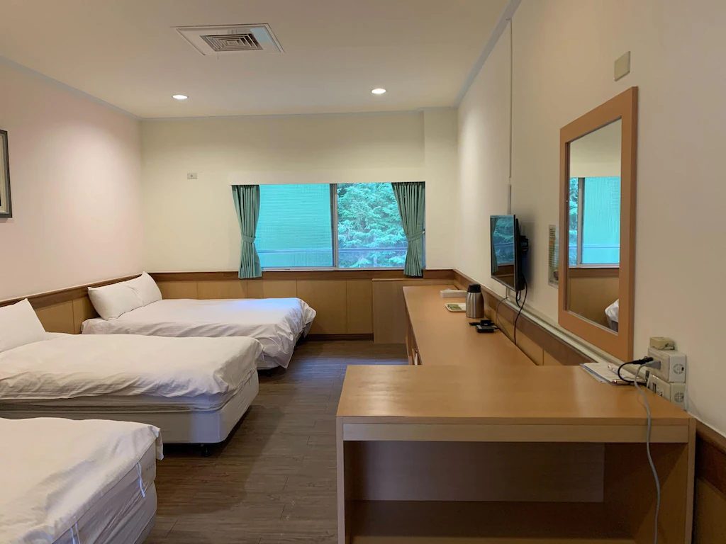 溫馨舒適的客房空間，大面窗戶引入自然光線，讓人待在房內也能感受森林氣息。