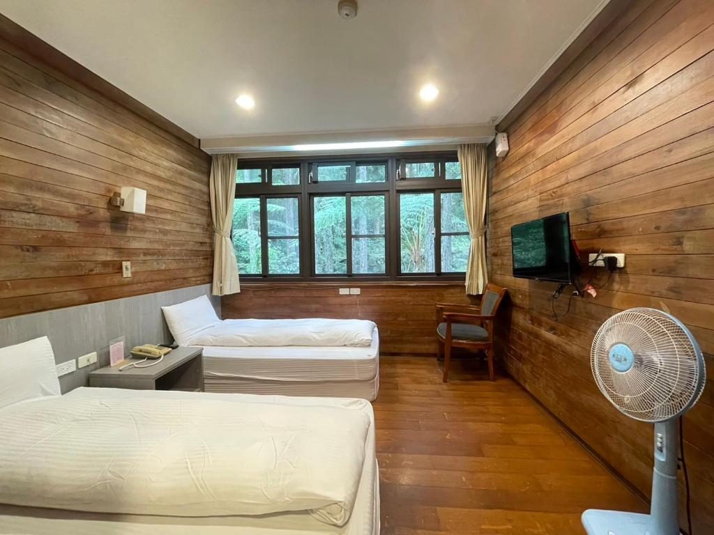 森林間的小木屋與清晨的霧氣，呈現寧靜的氛圍