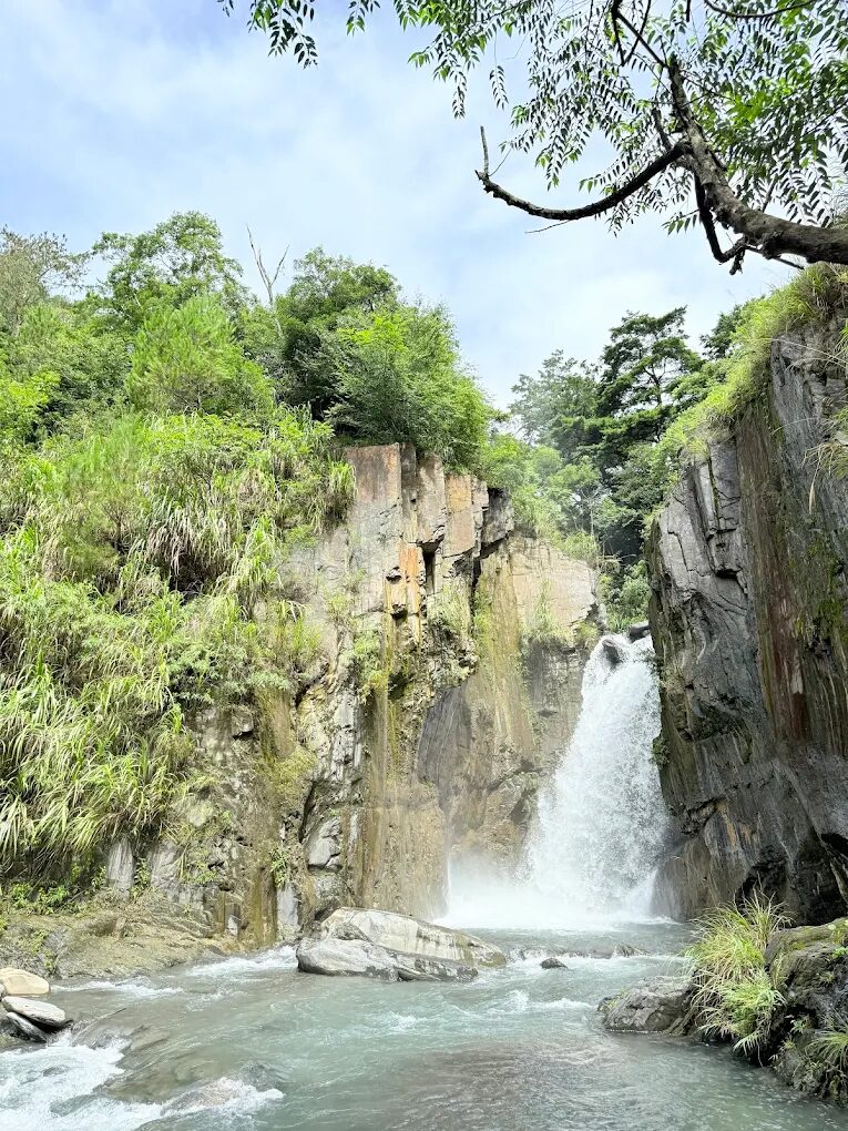 遊客在夢谷瀑布前的溪流步道漫步，享受森林浴