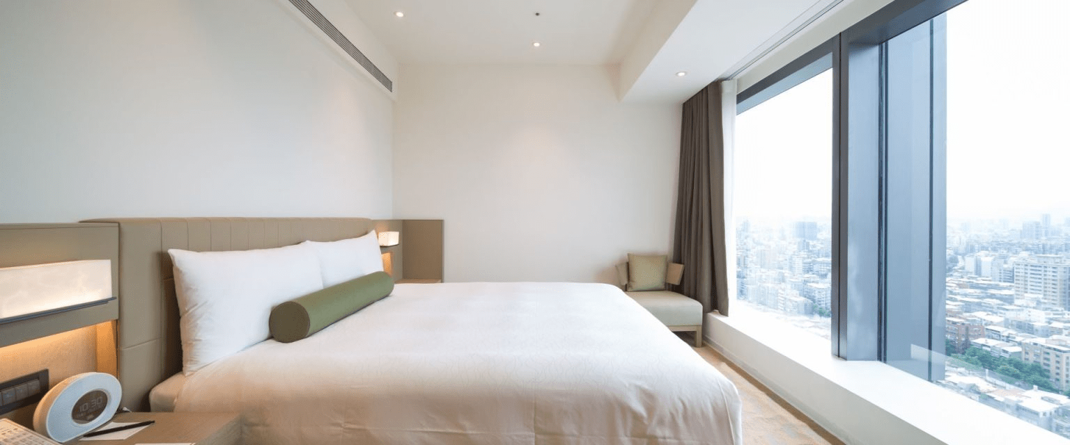 精緻客房內部配置，落地窗引進絕美城市景觀
