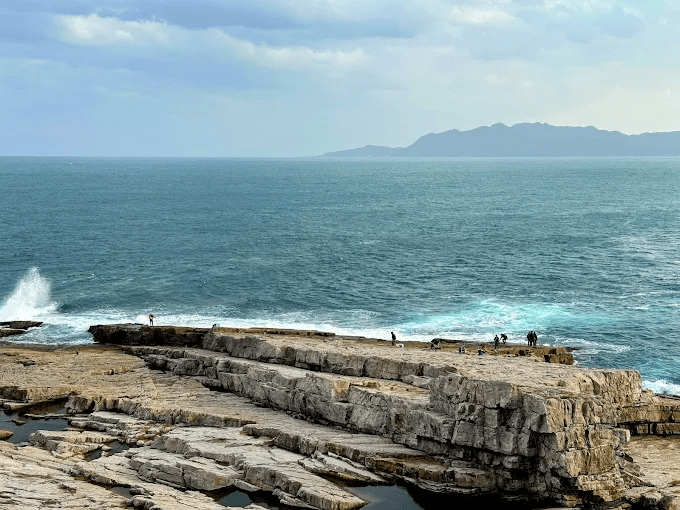 當浪聲貼近腳邊，在新北貢寮的龍洞灣散步，看見岩岸與海水交會的瞬間