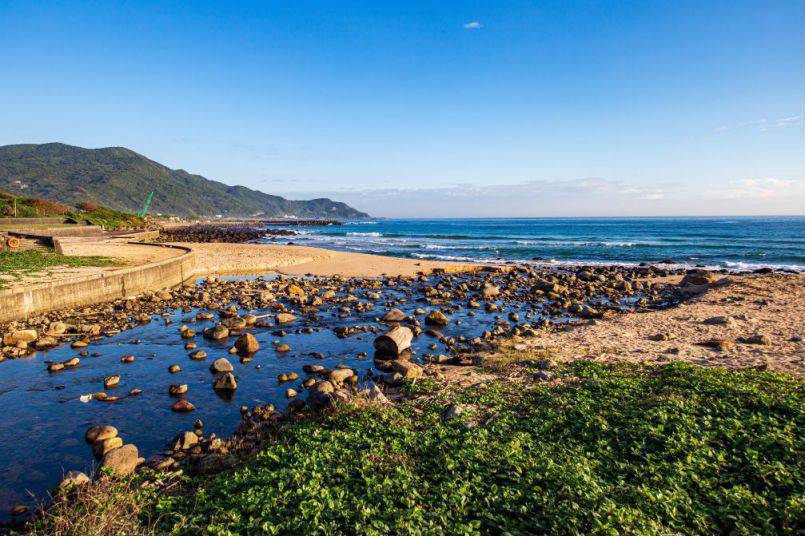 沿著濱海公路開往貢寮金沙灣，看海浪與夕陽在沙灘上慢慢鋪展