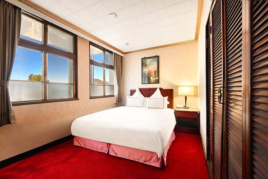 阿里山賓館古樸優雅的客房窗外，清晨的雲海與山巒交織成畫