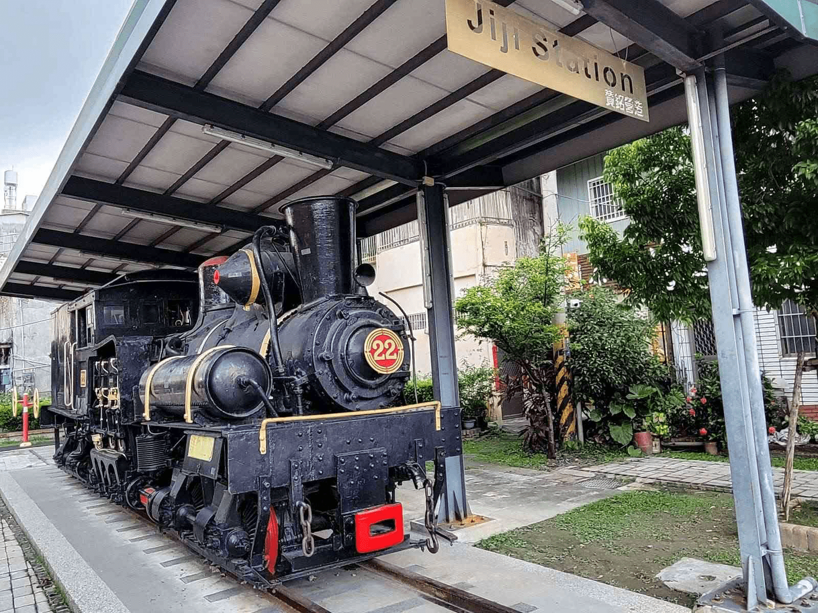 集集車站外的綠色隧道景觀，陽光透過樟樹葉縫灑落，景色宜人