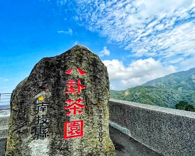 八卦茶園地標石碑，這裡是遊客留下足跡的最佳地點，背後即是綿延不絕的茶山。