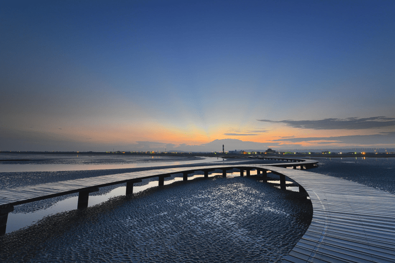 當風車與夕陽映在高美濕地水面，讓光影流動成為台中最溫柔的海線風景