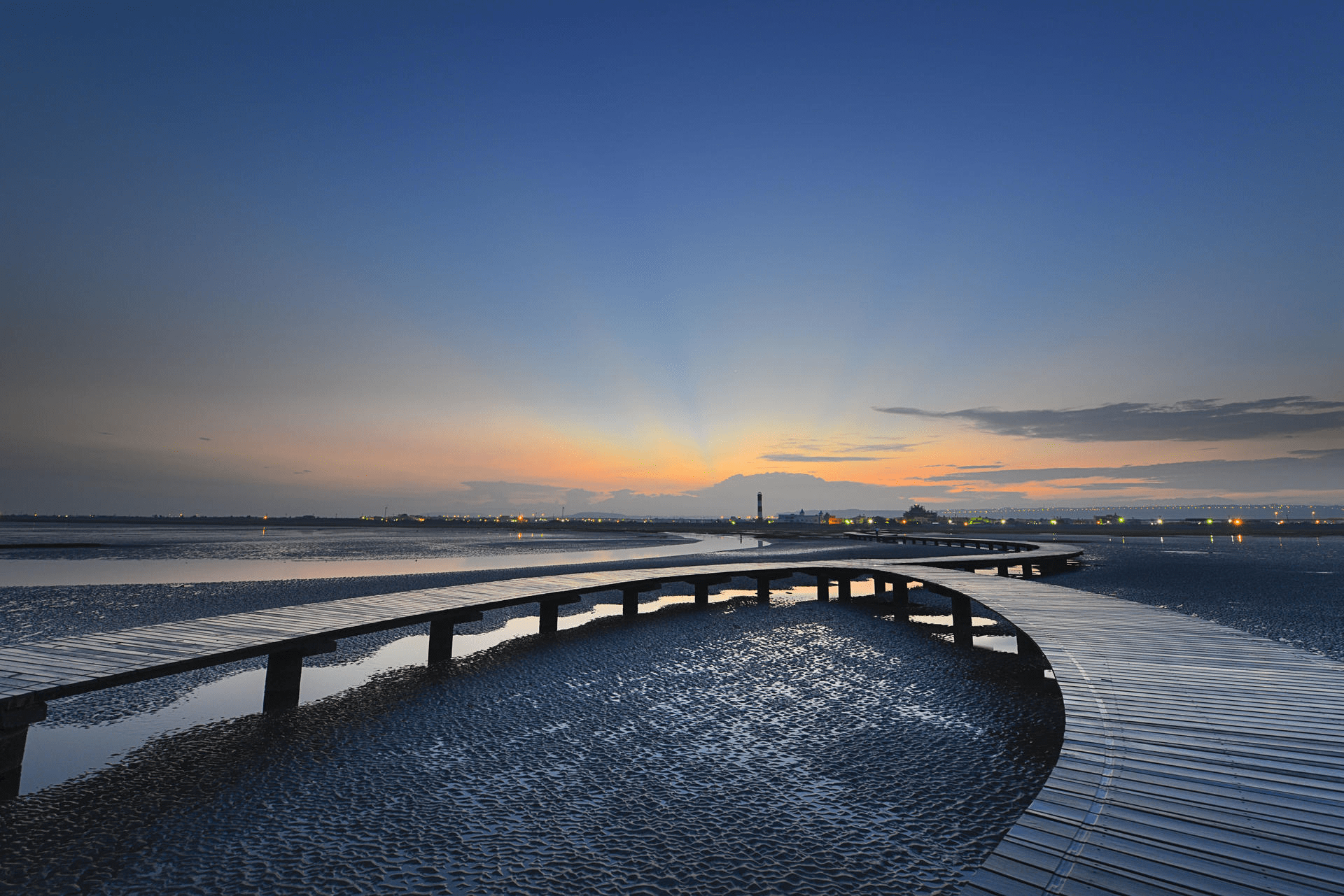 當風車與夕陽映在高美濕地水面，讓光影流動成為台中最溫柔的海線風景