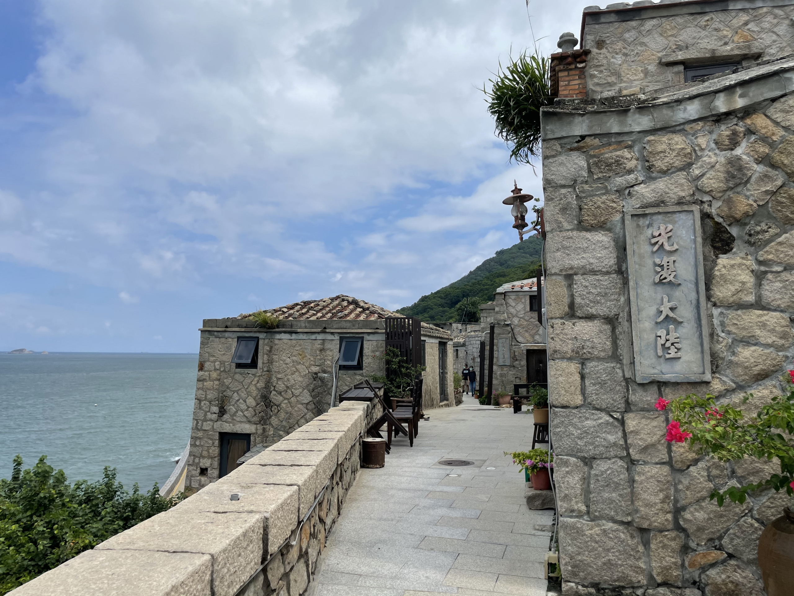 從高處俯瞰芹壁聚落，石屋群與蔚藍海洋構成如畫的風景