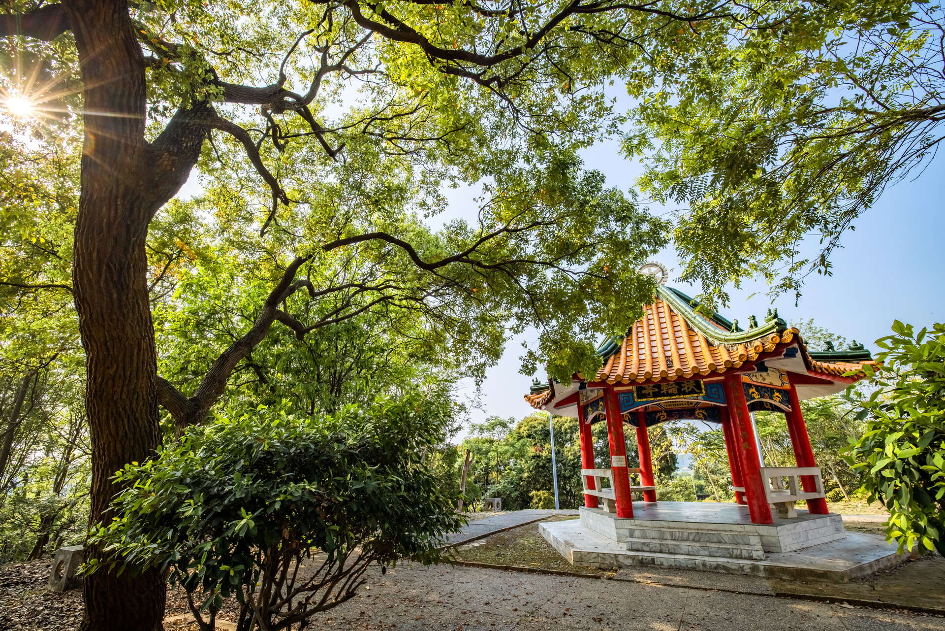 當夕陽灑落山丘與遠方城市之間，走進百果山遊憩區讓風景充滿溫暖層次