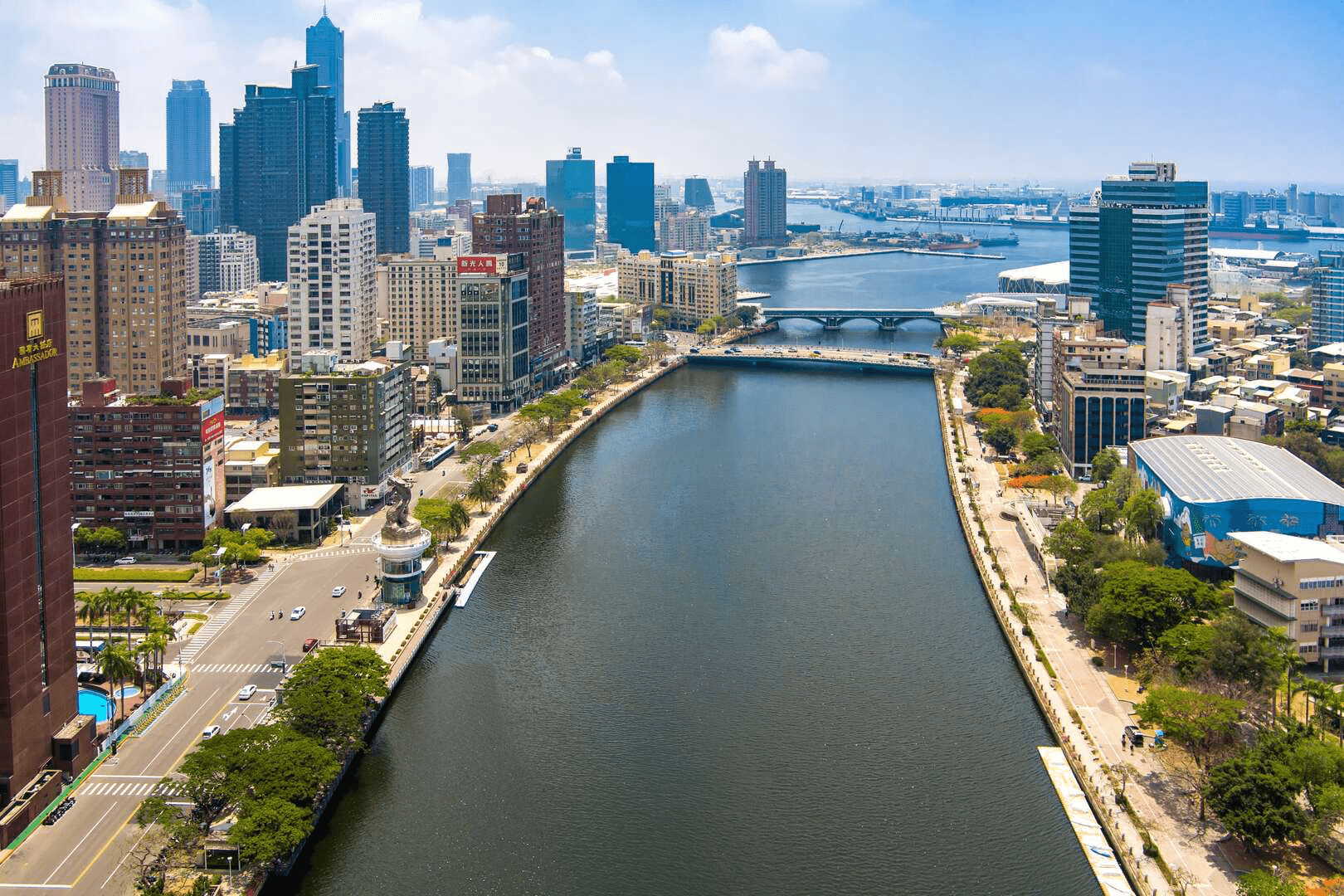 愛河兩岸高樓林立與河水倒影交織，展現出高雄國際化都市的氣派風景