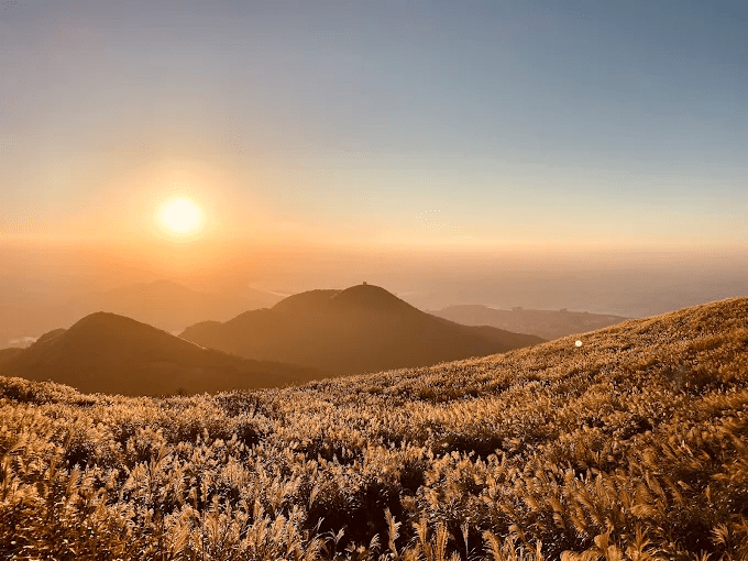 在陽明山大屯山迎風站著等夕陽落下，雲海悄悄把台北盆地整個托起來