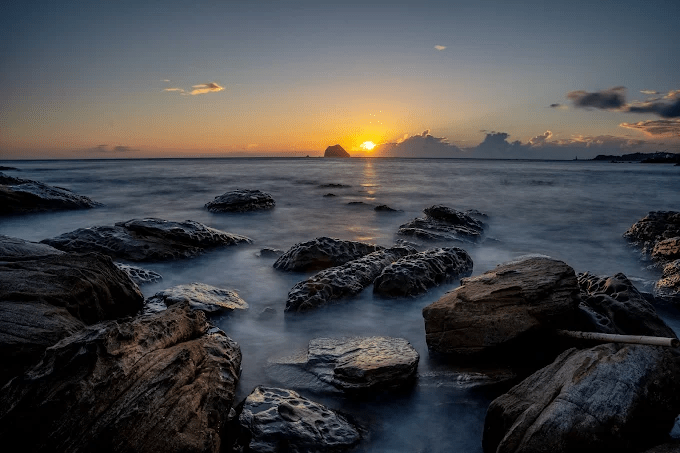 傍晚時分的外木山濱海廊帶，夕陽餘暉將海面染成一片金黃，景色如夢似幻