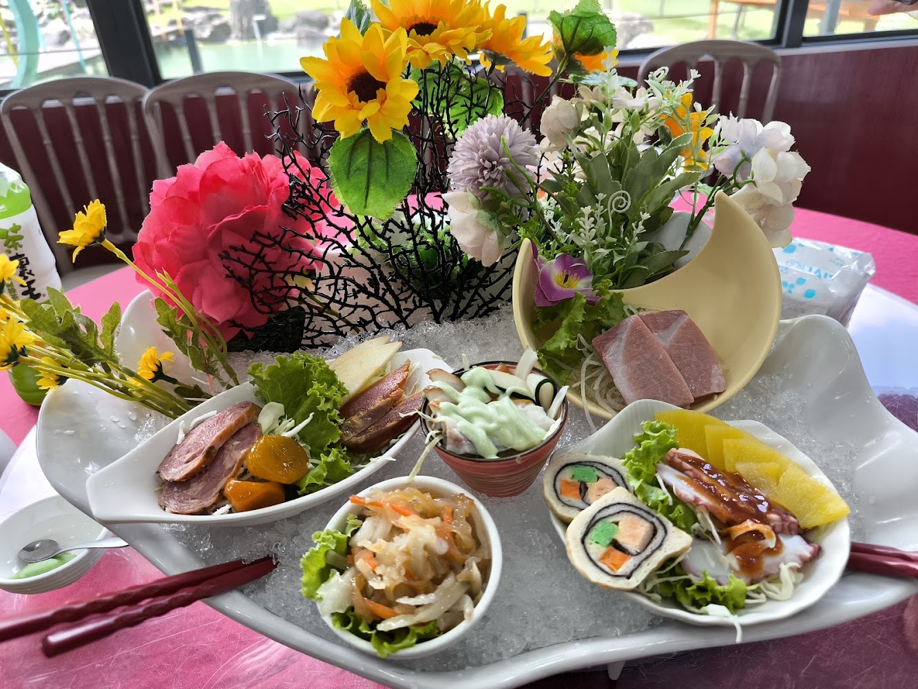 精緻日式前菜拼盤，包含生魚片、壽司卷與煙燻鴨胸