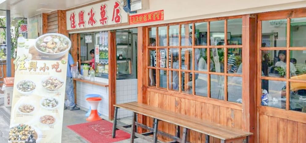 佳興冰菓店門口有菜單看板，介紹多種小吃和飲品，店內外有顧客正在用餐