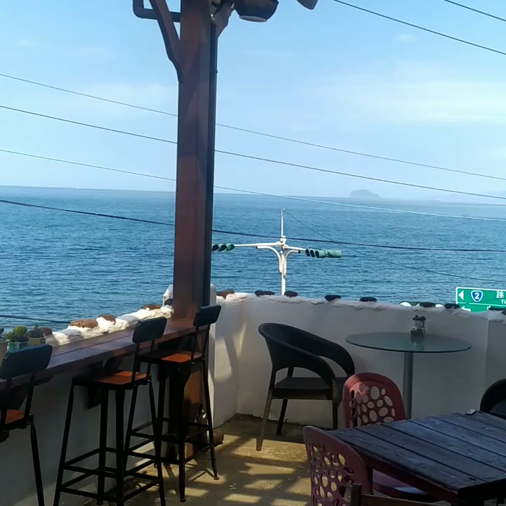 戶外高腳椅與圓桌面向蔚藍海面