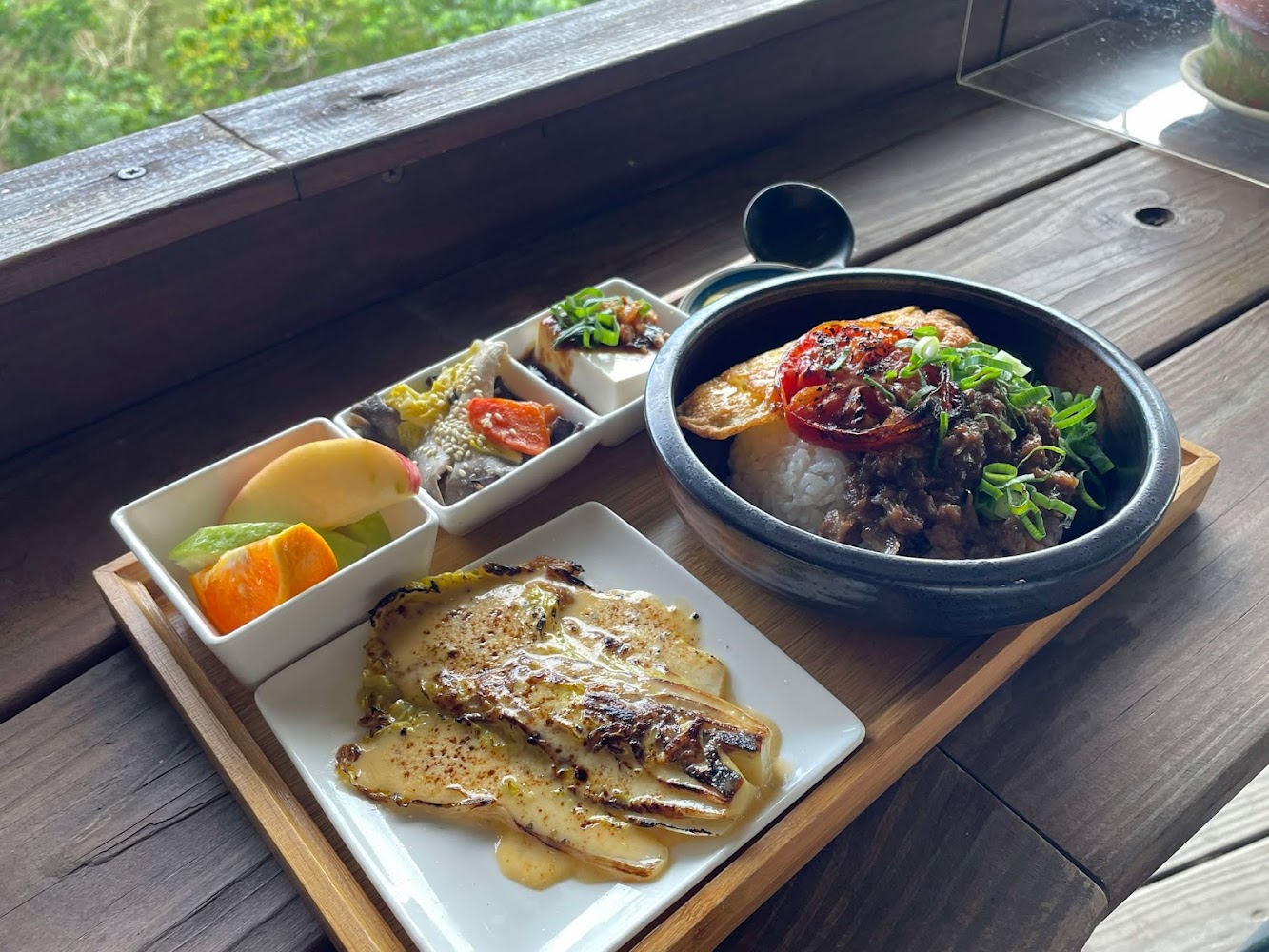 這張圖片展示一份精緻的日式套餐，有牛肉蓋飯、烤蔬菜、冷豆腐、時蔬小菜及新鮮水果，擺盤美觀，色彩豐富。