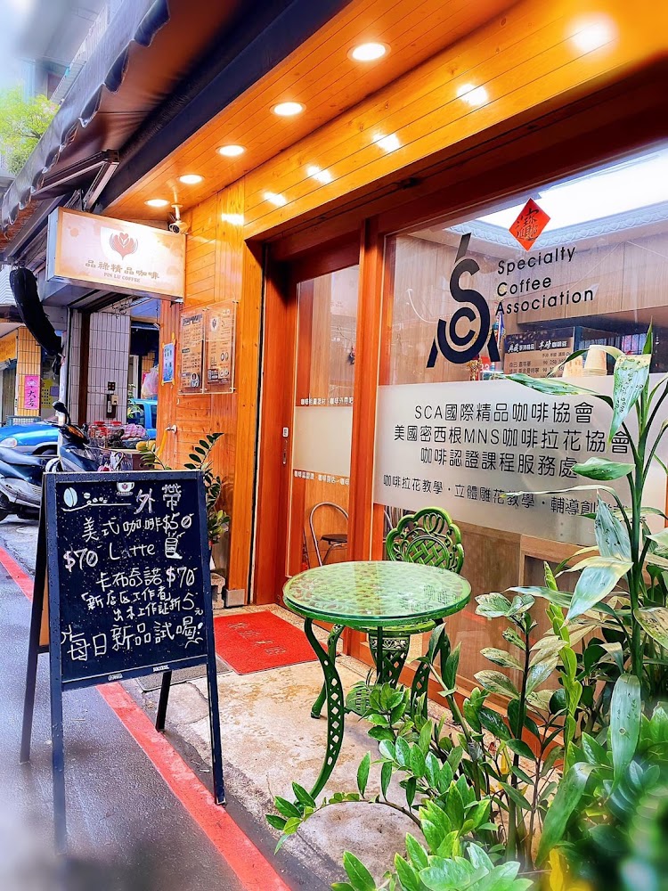 門口有黑板豆單與綠色戶外桌椅的咖啡店