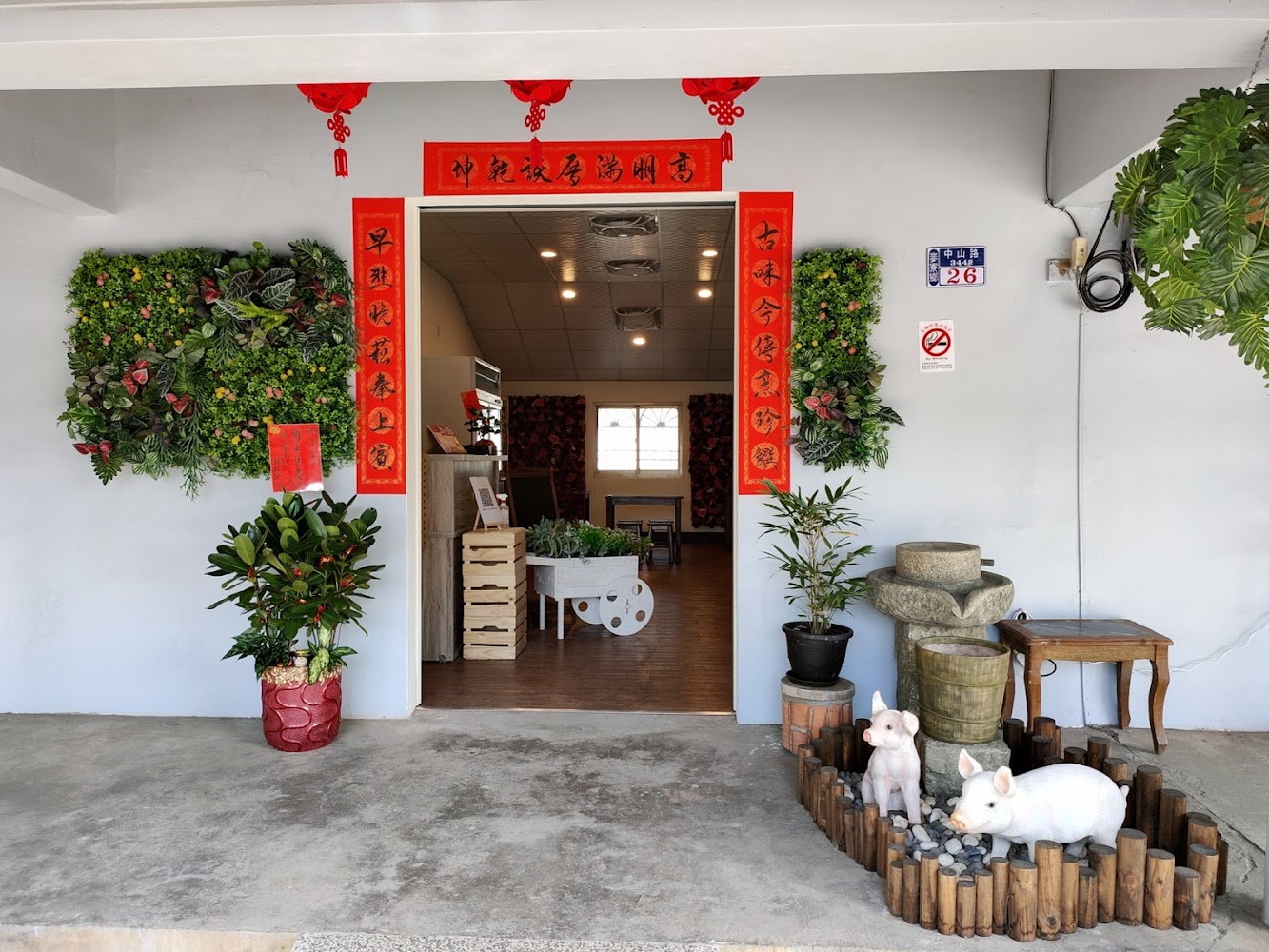 雲林古早厝餐廳入口，掛有春聯與燈籠並有植栽牆