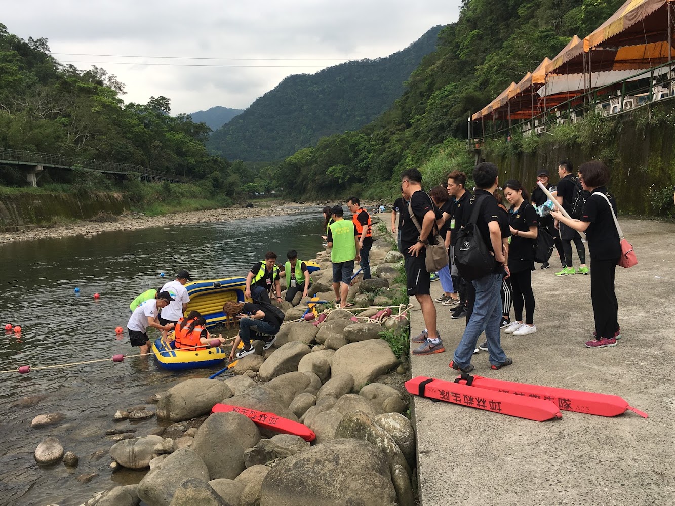 河邊戶外活動與穿救生衣準備搭乘橡皮艇的人群