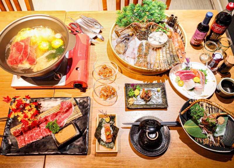豐盛的日式料理套餐，包含火鍋、刺身與海鮮拼盤