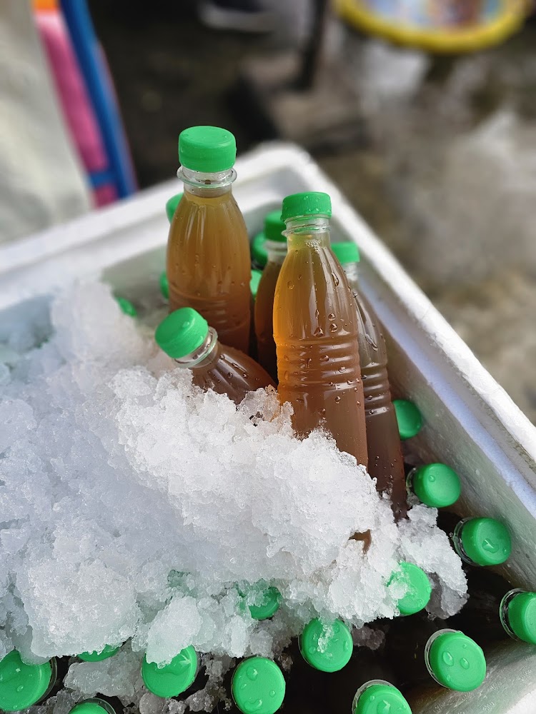 冰塊中放著多瓶褐色石花露飲料,等待冰鎮販售