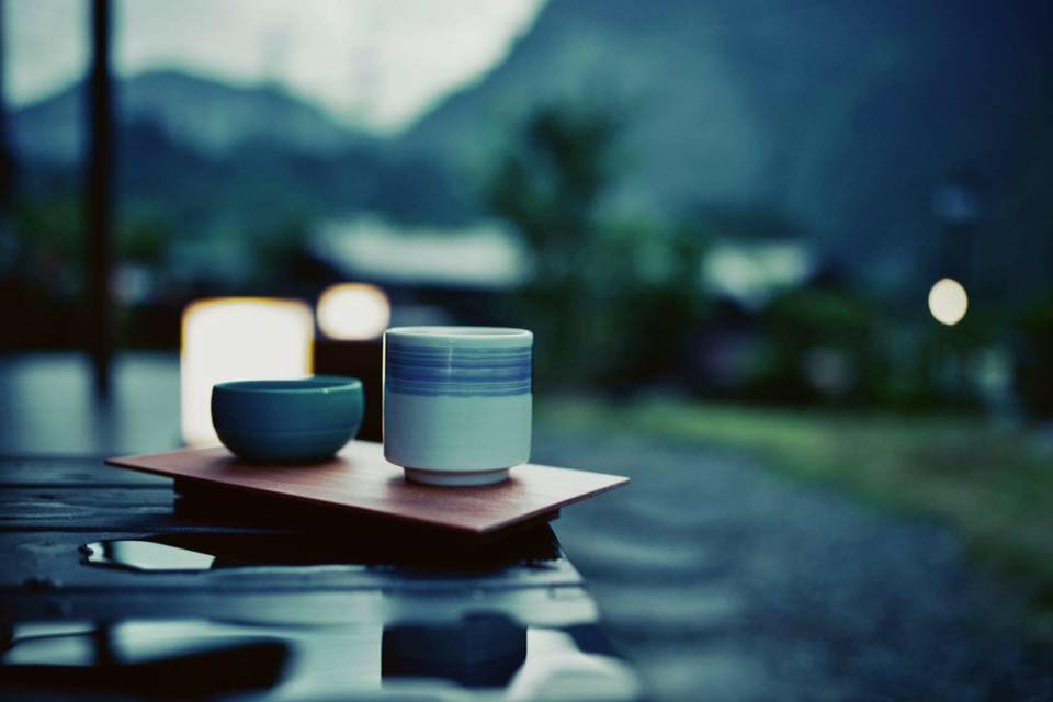 茶杯與小碗放在木桌托盤上背景有山景