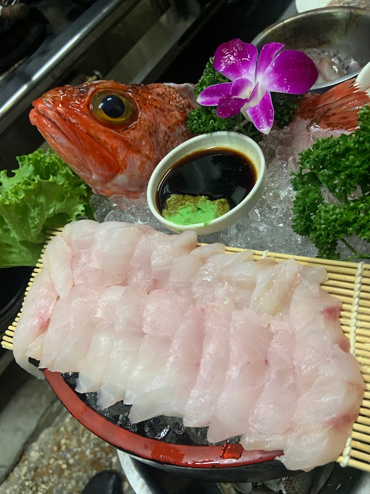 精緻生魚片拼盤，擺有魚頭、魚肉切片、芥末與醬油