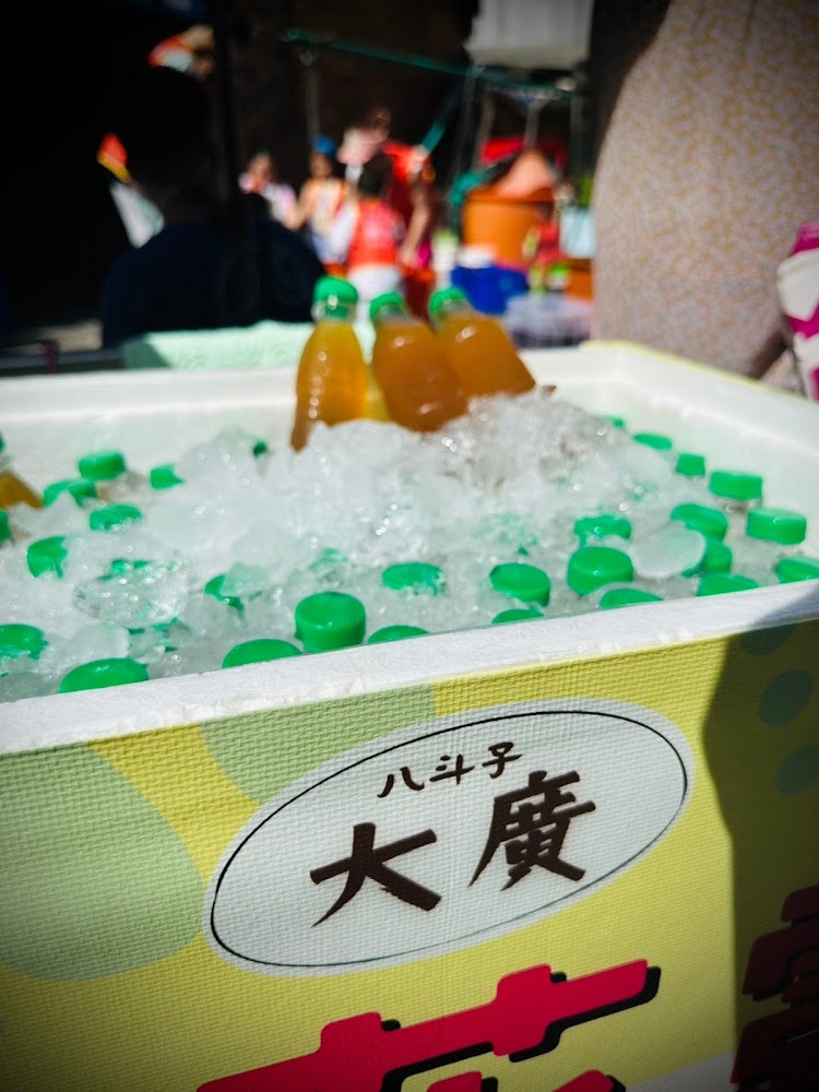 保麗龍箱裝滿冰鎮飲料瓶,前方標有八斗子大廣