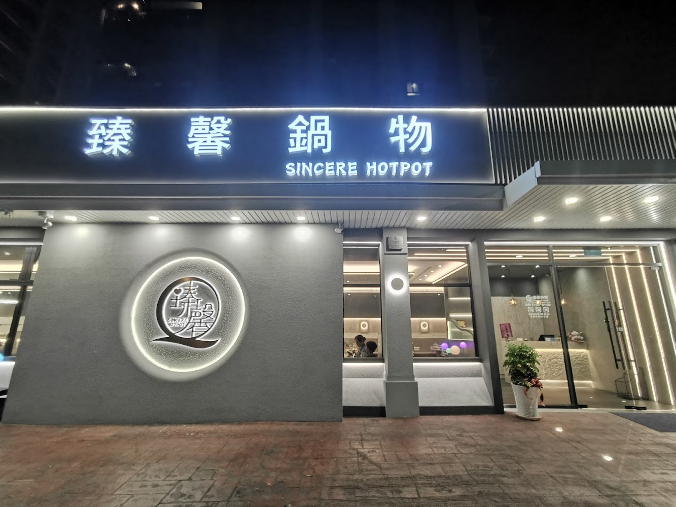 臻馨鍋物美術館店外觀，裝潢現代明亮，門口有醒目的招牌。