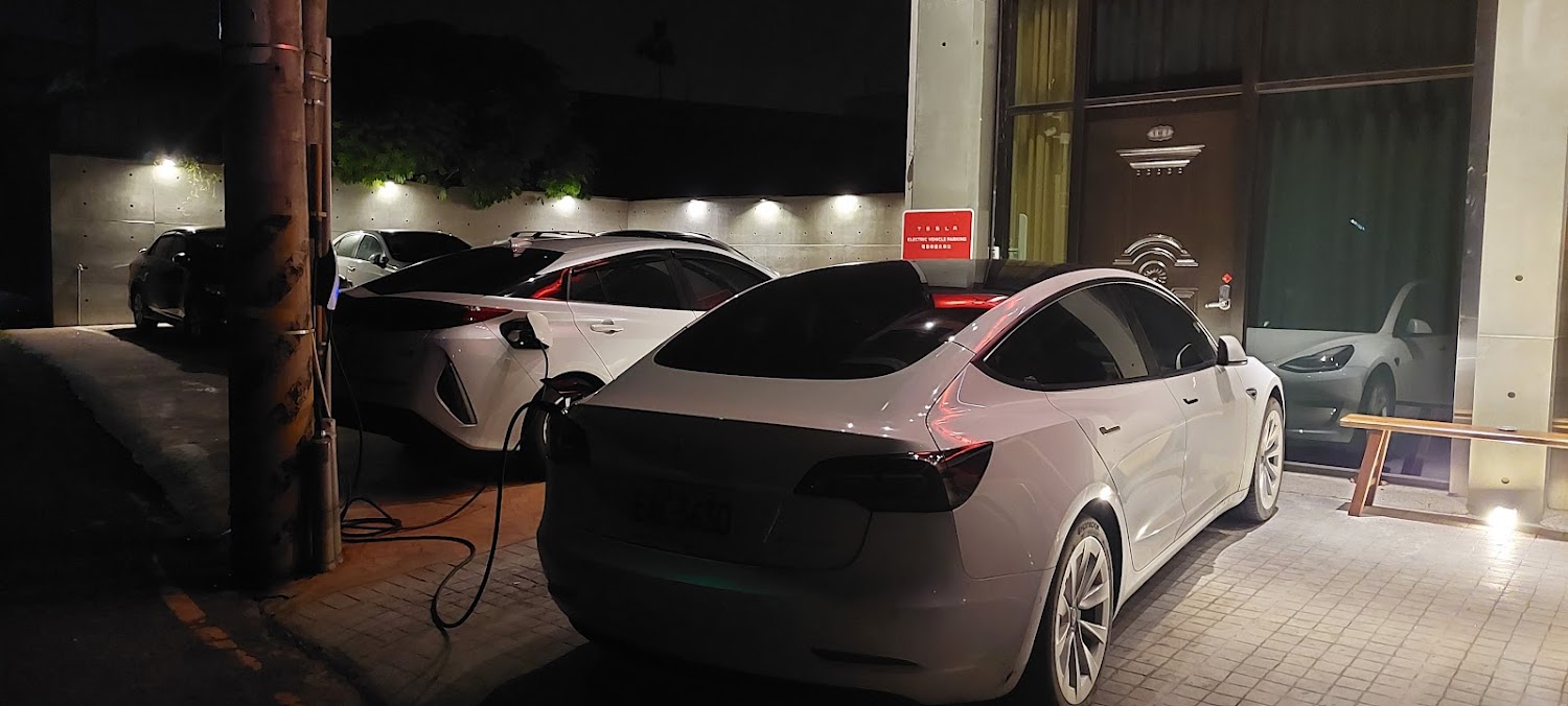 幾輛白色電動車停在充電車位並使用充電樁充電