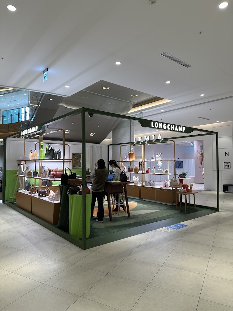 位於室內百貨的 Longchamp 台中LaLaport店，兩位顧客正在選購包款