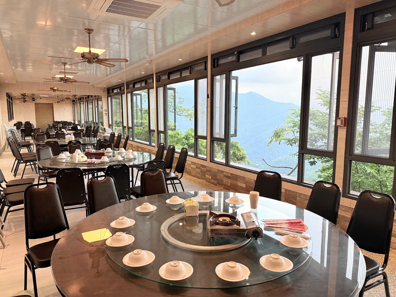 餐廳內部寬敞明亮，設有多張圓桌與大片景觀窗
